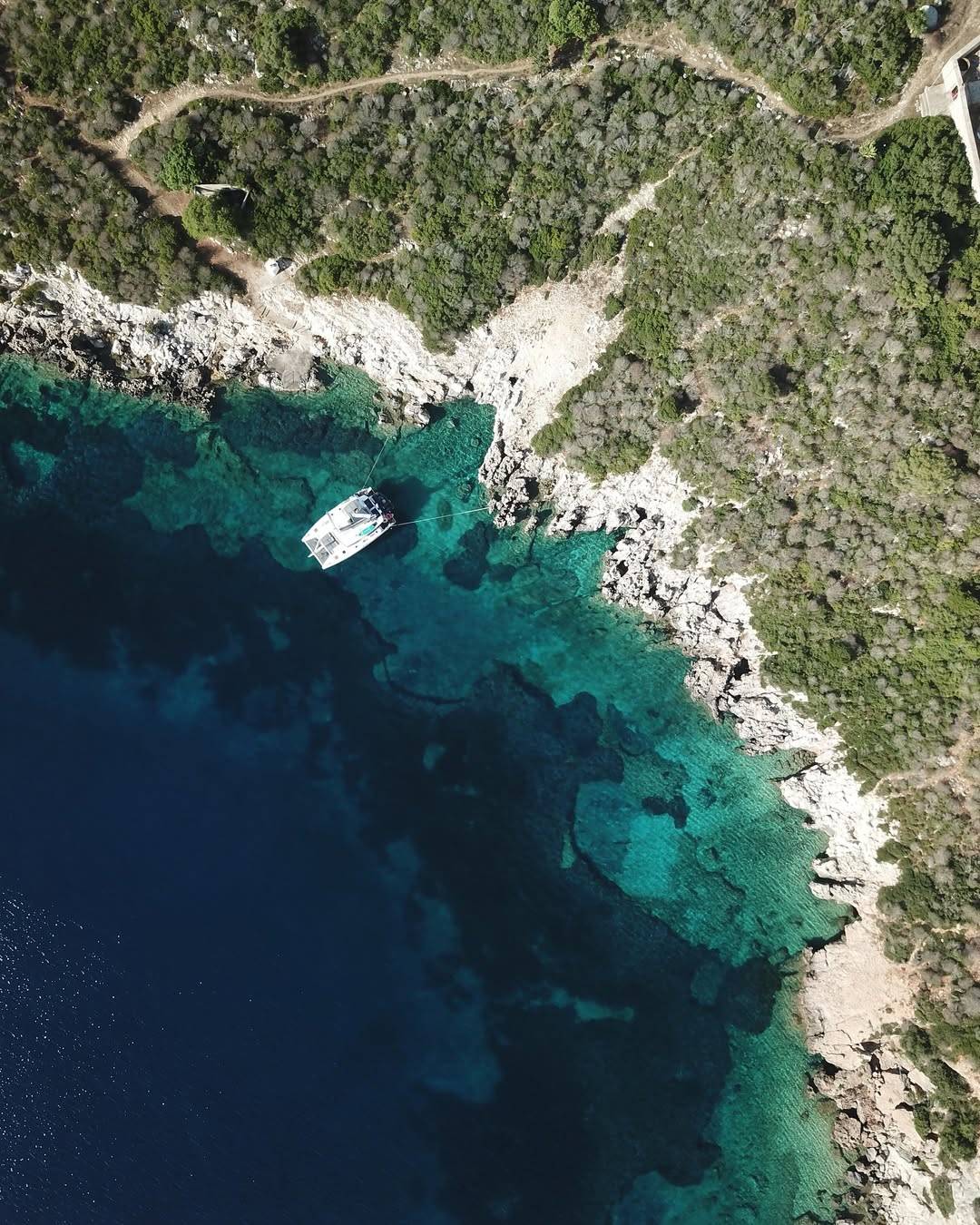 Alegria catamaran is anchored near the rocky coast of Proti Island in Messinia, Greece, surround (1)