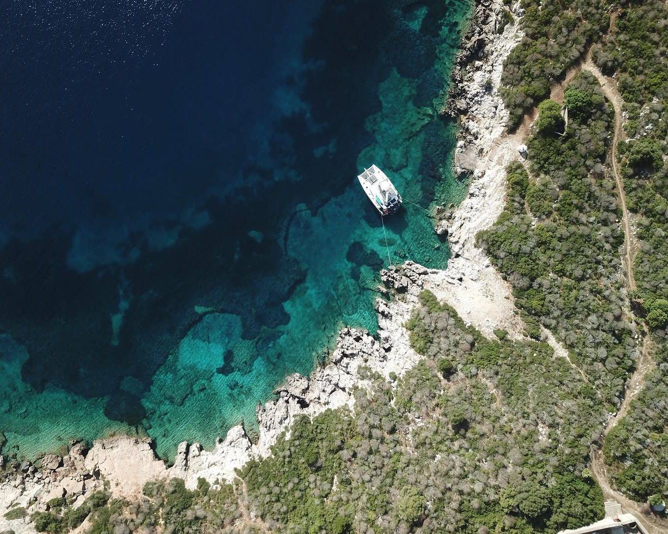 Alegria catamaran is anchored near the rocky coast of Proti Island in Messinia, Greece, surround (1)